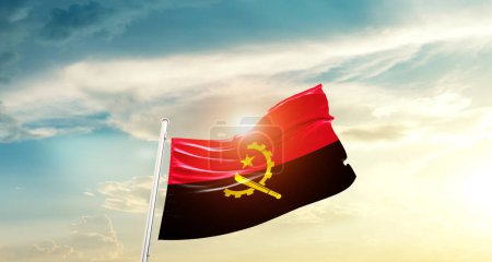 Foto de Angola ondeando bandera en hermoso cielo con sol - Imagen libre de derechos
