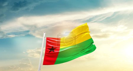 Téléchargez les photos : Guinea-Bissau waving flag in beautiful sky with sun - en image libre de droit