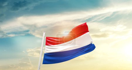 Foto de Netherlands waving flag in beautiful sky with sun - Imagen libre de derechos