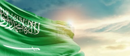 Foto de Saudi Arabia waving flag in beautiful sky with sun - Imagen libre de derechos