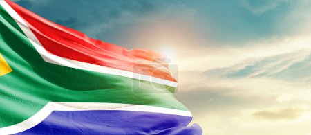 Foto de South Africa waving flag in beautiful sky with sun - Imagen libre de derechos