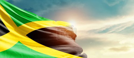 Téléchargez les photos : Jamaïque agitant drapeau dans un beau ciel avec soleil - en image libre de droit