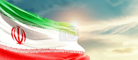 Téléchargez les photos : Iran agitant le drapeau dans un ciel magnifique avec le soleil - en image libre de droit