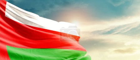 Foto de Omán ondeando bandera en hermoso cielo con sol - Imagen libre de derechos