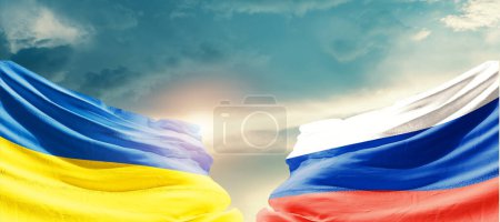 Téléchargez les photos : Ukraine et la Russie agitant des drapeaux dans un ciel magnifique avec le soleil - en image libre de droit