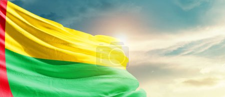 Photo for Guinea-Bissau waving flag in beautiful sky with sun - Royalty Free Image