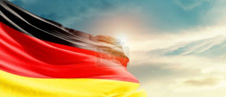 Photo for Germany waving flag in beautiful sky with sun - Royalty Free Image