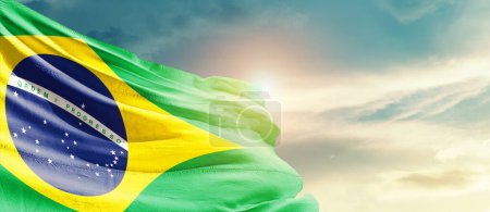 Téléchargez les photos : Brazil waving flag in beautiful sky with sun - en image libre de droit