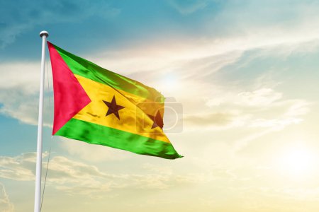 Foto de Sao Tome and Principe waving flag in beautiful sky with sun - Imagen libre de derechos