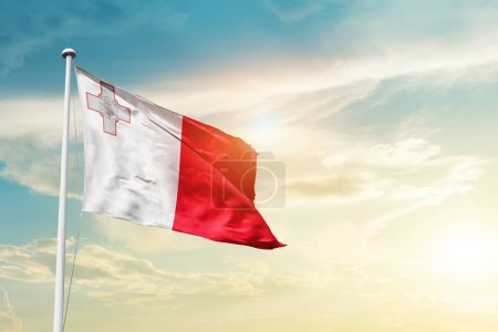 Téléchargez les photos : Malte agitant le drapeau dans un ciel magnifique avec le soleil - en image libre de droit