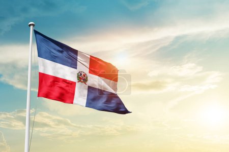 Photo for Dominican Republic waving flag in beautiful sky with sun - Royalty Free Image