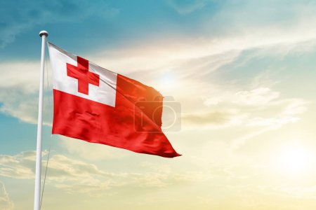 Foto de Tonga ondeando bandera en el hermoso cielo con sol - Imagen libre de derechos