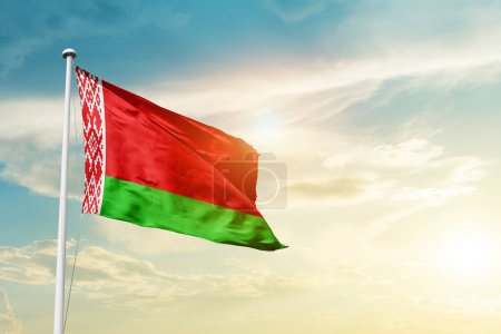 Téléchargez les photos : Belarus waving flag in beautiful sky with sun - en image libre de droit