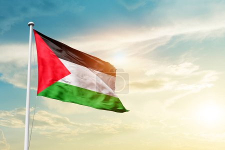 Téléchargez les photos : Palestine agitant le drapeau dans un ciel magnifique avec le soleil - en image libre de droit