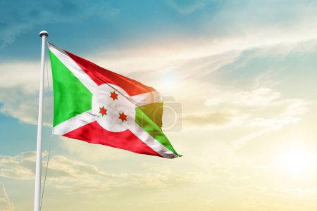Photo for Burundi waving flag in beautiful sky with sun - Royalty Free Image