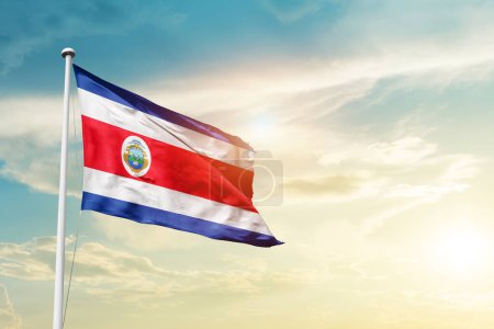Téléchargez les photos : Costa Rica waving flag in beautiful sky with sun - en image libre de droit
