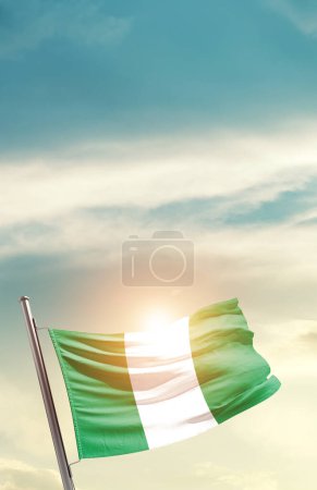Photo for Nigeria waving flag in beautiful sky with sun - Royalty Free Image
