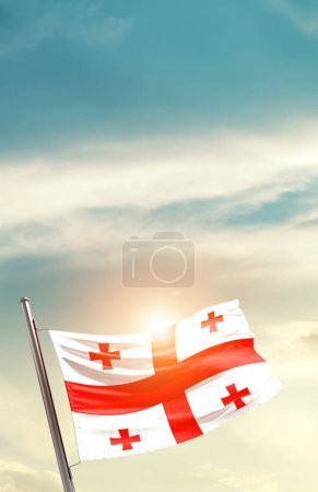 Photo for Georgia waving flag in beautiful sky with sun - Royalty Free Image