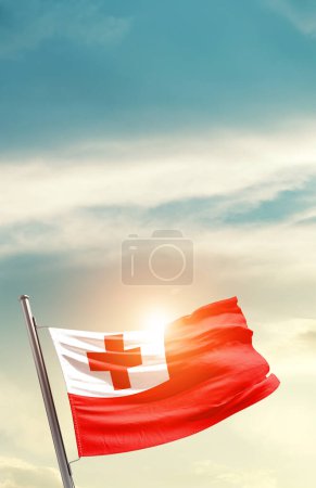 Foto de Tonga tongan ondeando bandera en el hermoso cielo con sol - Imagen libre de derechos