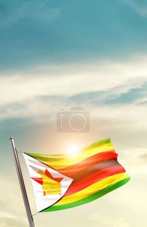 Téléchargez les photos : Zimbabwe agitant le drapeau dans un ciel magnifique avec le soleil - en image libre de droit