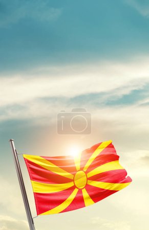 Foto de North Macedonia waving flag in beautiful sky with sun - Imagen libre de derechos