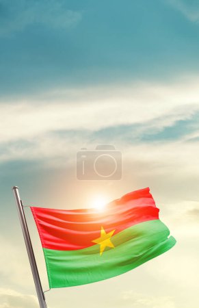 Téléchargez les photos : Drapeau du Burkina Faso agitant un beau ciel avec soleil - en image libre de droit