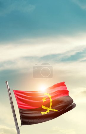 Téléchargez les photos : Angola waving flag in beautiful sky with sun - en image libre de droit