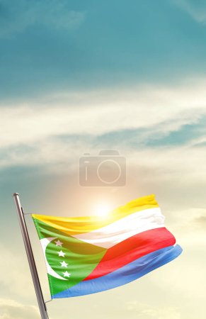 Foto de Comoras ondeando bandera en hermoso cielo con sol - Imagen libre de derechos