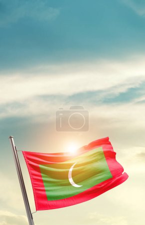 Téléchargez les photos : Maldives waving flag in beautiful sky with sun - en image libre de droit