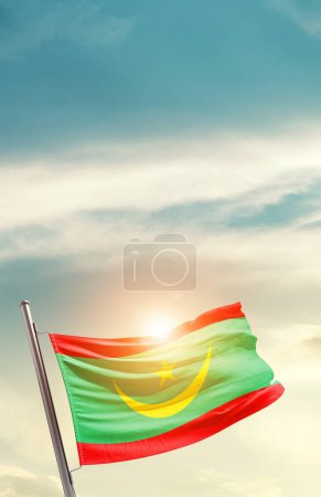 Photo for Mauritania waving flag in beautiful sky with sun - Royalty Free Image