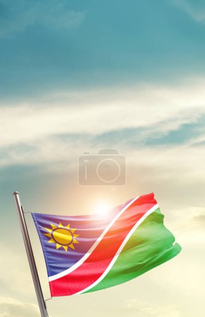 Foto de Namibia ondeando bandera en hermoso cielo con sol - Imagen libre de derechos