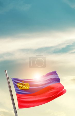 Téléchargez les photos : Liechtenstein waving flag in beautiful sky with sun - en image libre de droit