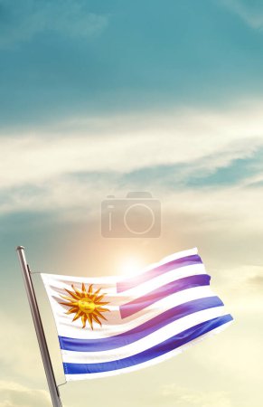 Téléchargez les photos : Uruguay agitant le drapeau dans un ciel magnifique avec le soleil - en image libre de droit