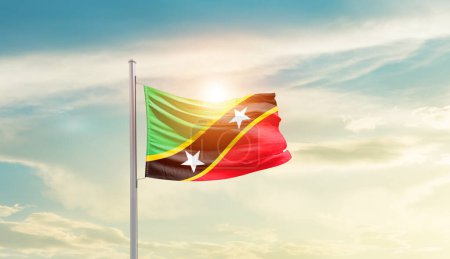 Foto de Saint Kitts and Nevis waving flag in beautiful sky with sun - Imagen libre de derechos
