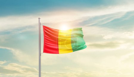 Téléchargez les photos : Guinea waving flag in beautiful sky with sun - en image libre de droit