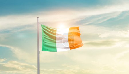 Foto de Irlanda ondeando bandera en hermoso cielo con sol - Imagen libre de derechos