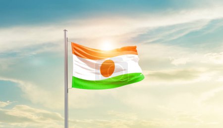 Photo for Niger waving flag in beautiful sky with sun - Royalty Free Image