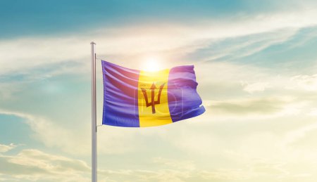 Téléchargez les photos : Barbados waving flag in beautiful sky with sun - en image libre de droit