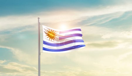 Téléchargez les photos : Uruguay waving flag in beautiful sky with sun - en image libre de droit