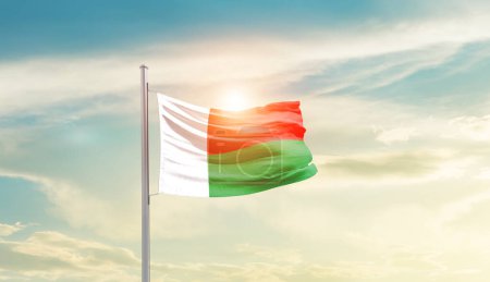 Photo for Madagascar waving flag in beautiful sky with sun - Royalty Free Image