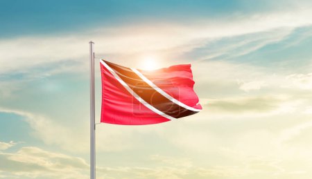 Téléchargez les photos : Trinité-et-Tobago agitant le drapeau dans un ciel magnifique avec le soleil - en image libre de droit