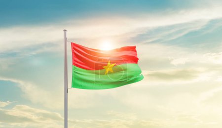 Téléchargez les photos : Burkina Faso waving flag in beautiful sky with sun - en image libre de droit