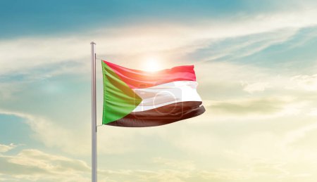 Téléchargez les photos : Sudan waving flag in beautiful sky with sun - en image libre de droit