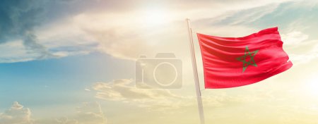 Foto de Marruecos ondeando bandera en hermoso cielo con sol - Imagen libre de derechos