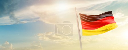 Foto de Alemania ondeando bandera en hermoso cielo con sol - Imagen libre de derechos