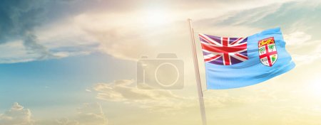Foto de Fiyi ondeando bandera en el hermoso cielo con sol - Imagen libre de derechos