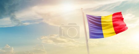Foto de Romania waving flag in beautiful sky with sun - Imagen libre de derechos