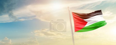 Foto de Palestina ondeando bandera en hermoso cielo con sol - Imagen libre de derechos