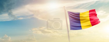 Téléchargez les photos : Tchad agitant le drapeau dans un ciel magnifique avec le soleil - en image libre de droit