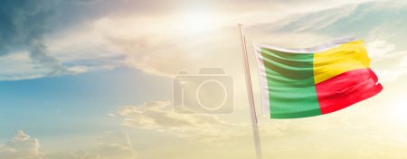 Foto de Benin ondeando bandera en el hermoso cielo con sol - Imagen libre de derechos